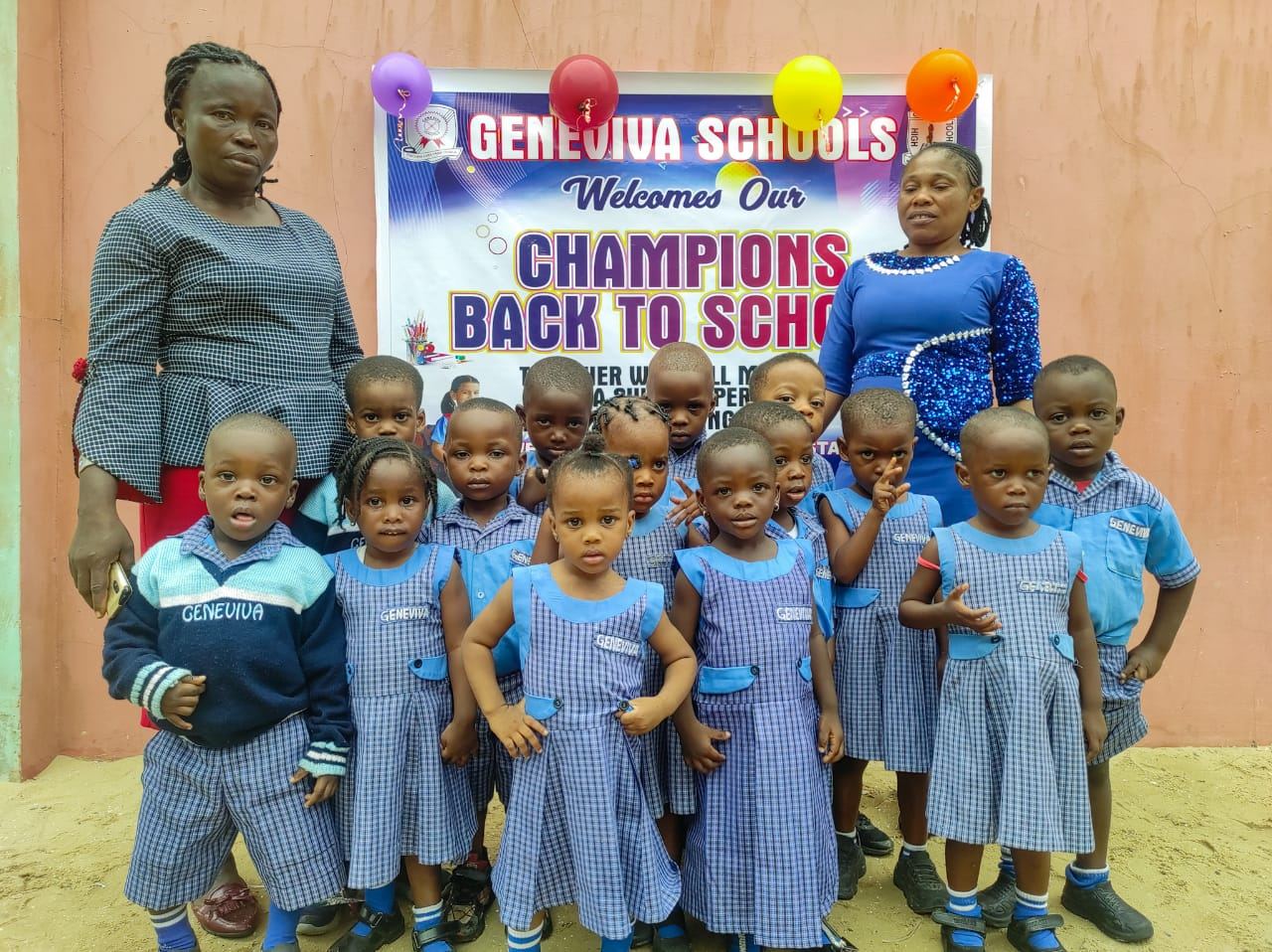 Nursery and primary pupils with teachers under the welcome banner