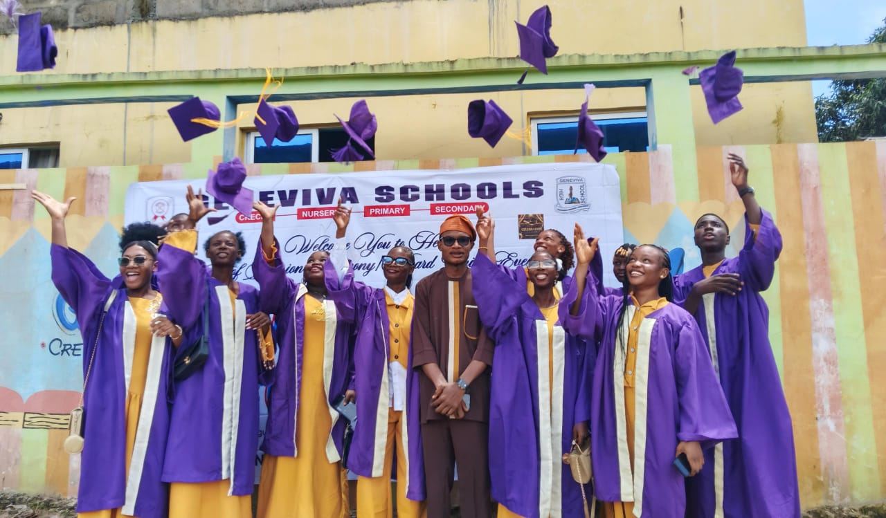 Geneviva graduands in purple gowns throwing their caps