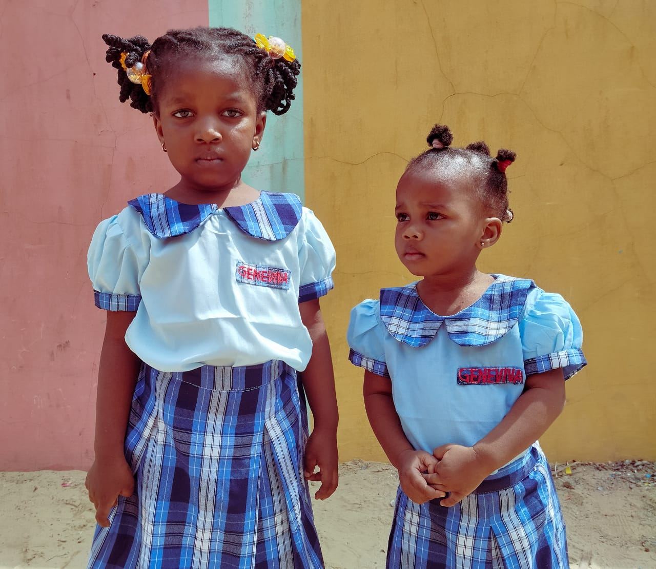Two Geneviva nursery pupils in their blue check uniforms